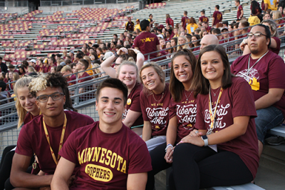 A group of Freshmen students sit in Huntington Bank Stadium during a Welcome Week event.