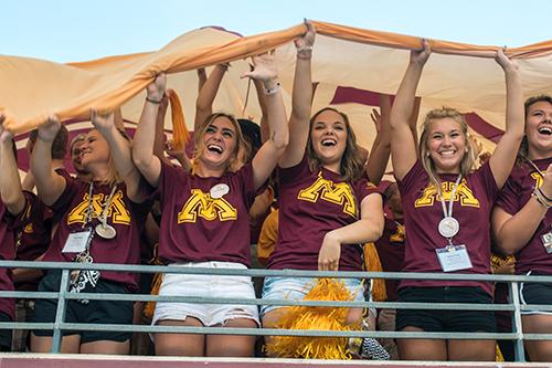 Freshmen in the stands pull a giant UMN Flag overhead during Pride and Spirit
