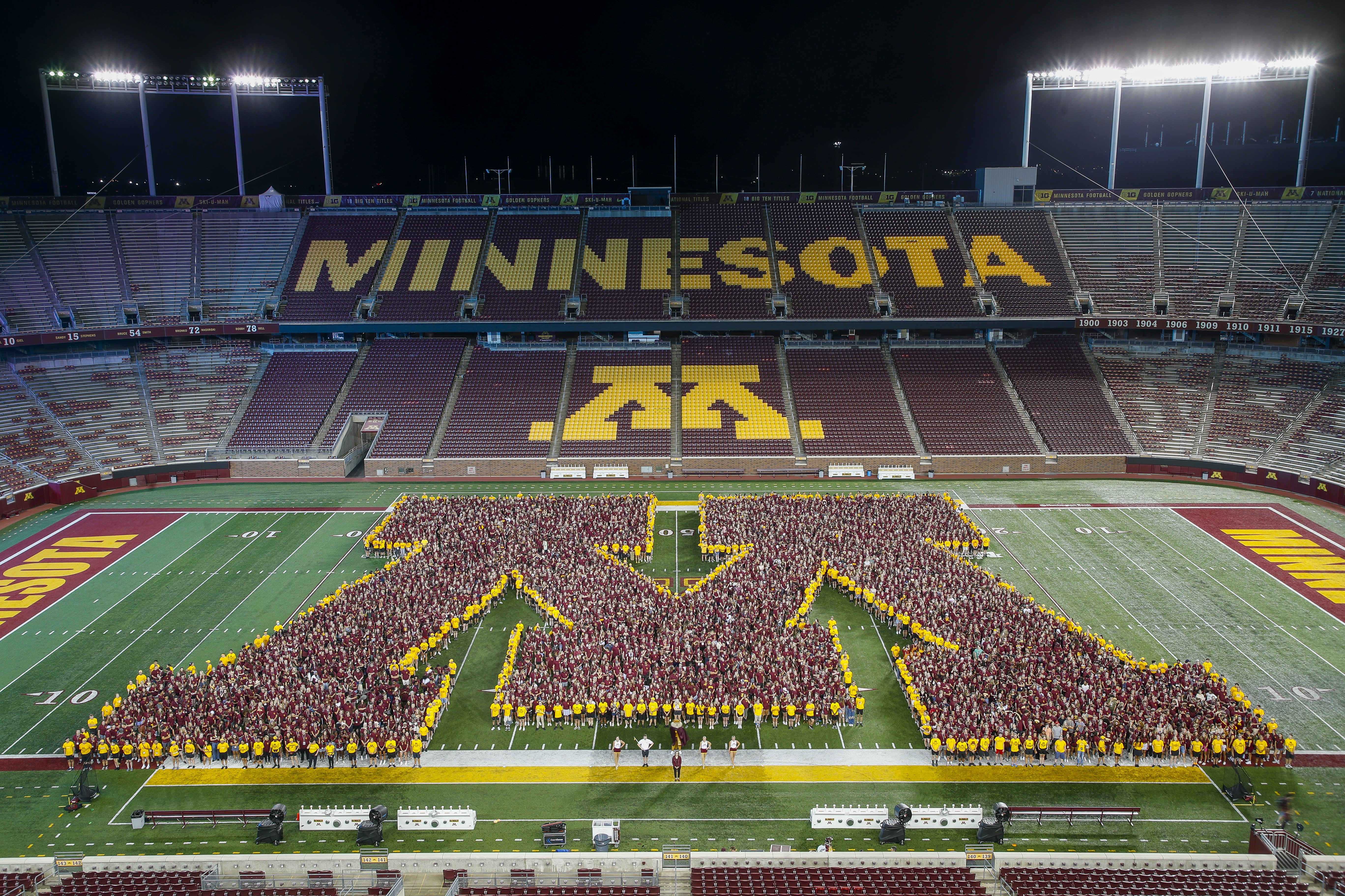 Students forming the letter M on the stadium field