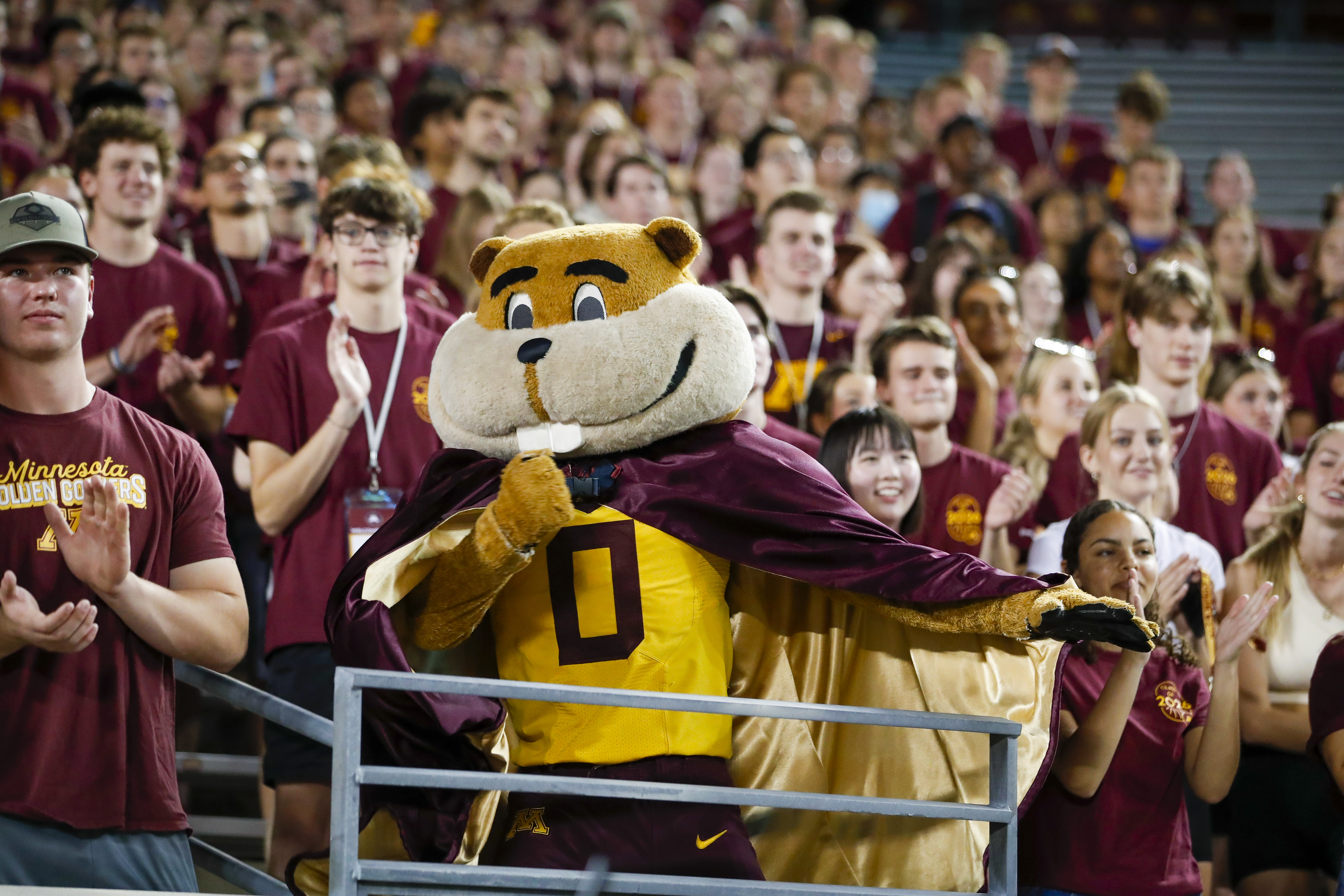Goldy the Gopher cheering with fans in the stands
