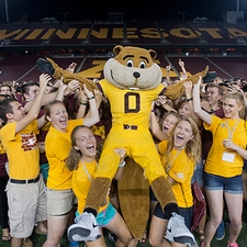 Students from the Marching Band and Freshman Welcome Week hold up Goldy Gopher