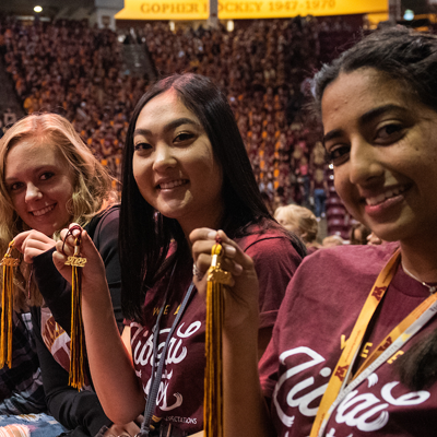 Students hold up their graduation year tassles for the camera during Freshman Convocation